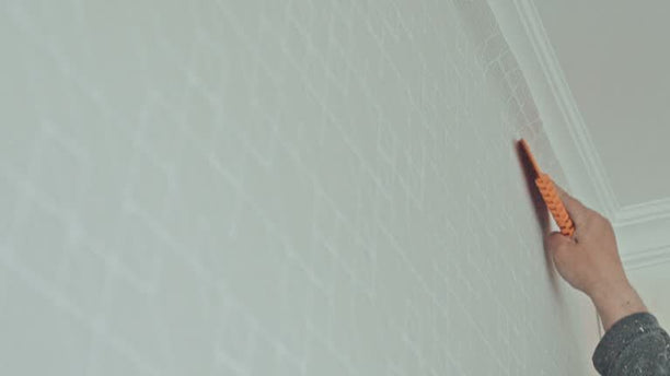 Hanging wallpaper, smoothing it down with a brush